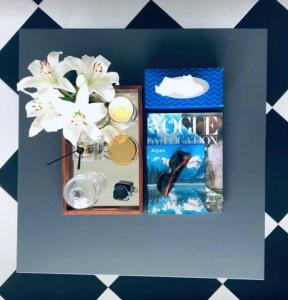 a box with a vase of flowers and a book at Cabo Verde Boutique Hotel in Batumi