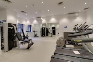a gym with treadmills and ellipticals in a room at La Casa Suites Slough in Slough