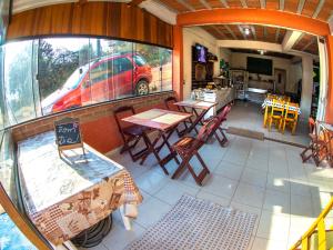 - Vistas al exterior de un restaurante con mesas y sillas en Villa da Vila, en Monte Verde