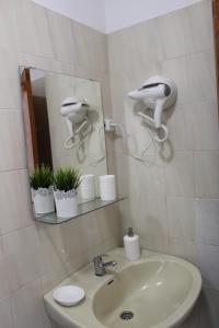 a bathroom sink with a hair dryer and a mirror at ApartamentosPlaya_Hermigua in Hermigua