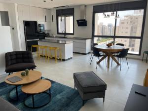 Il comprend une cuisine et un salon avec une table et des chaises. dans l'établissement #דירת יוקרה על הים Bluewave Beach Apartment#, à Giv‘at Olga