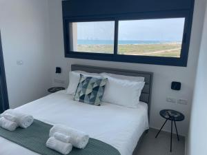 #דירת יוקרה על הים Bluewave Beach Apartment# في Giv‘at Olga: غرفة نوم عليها سرير وفوط