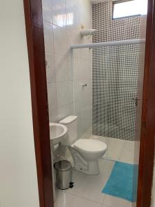 a bathroom with a toilet and a sink and a shower at Mellim Residence in Maragogi