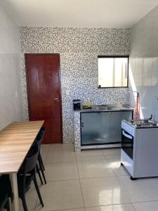 a kitchen with a table and a sink and a stove at Mellim Residence in Maragogi
