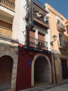 un edificio con un balcón con gente. en Mesón Kubano B&B en Sant Mateu