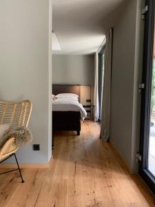 a bedroom with a bed and a wooden floor at Bungalow im Wald in Borkwalde