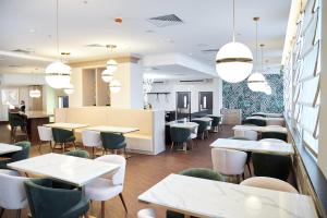 a dining room with tables and chairs and lights at River Palace Hotel in Saint Petersburg