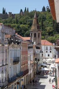a city street with buildings and a church at Templar Spot in Tomar
