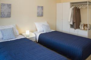 two beds in a room with blue and white at Templar Spot in Tomar