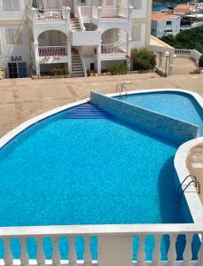 ein großer blauer Swimmingpool neben einem Gebäude in der Unterkunft Castell Sol - Arenal Den Castell in Arenal d'en Castell