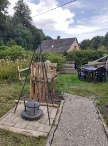 a swing set in a yard with a table and chairs at Au petit coin western in Le Hohwald