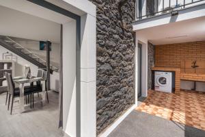 a kitchen and living room with a stone wall at Casa Da Portada in Calheta