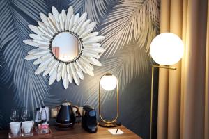 a mirror on a wall above a table with lamps at River Palace Hotel in Saint Petersburg