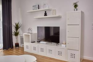 a white entertainment center with a flat screen tv at La vallée des Hortillonages in Amiens