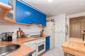 eine Küche mit blauen Schränken und einem Waschbecken in der Unterkunft FINALBIR MIMAR- Vistas al mar-Sea view- parking in Albir