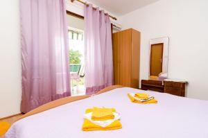 a bedroom with a bed with yellow towels on it at Guest House Kola in Slano