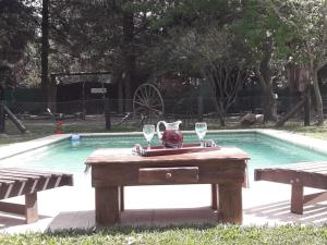 a picnic table with wine glasses next to a swimming pool at Casa de Campo La Renata in El Pato