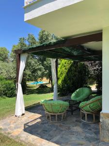 Navalmoral de BéjarにあるFinca La Fresneda en Sierra de Béjarの日よけの下にテーブルと椅子が置かれたパティオ