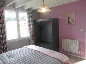 1 dormitorio con cama y ventana en La Belle symphonie, en Vieil-Moutier
