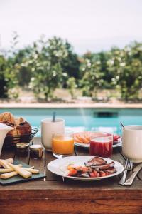 een tafel met borden met eten en drinken bij Mas des Herbes Blanches Hôtel & Spa – Relais & Châteaux in Joucas