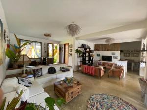 a living room with a white couch and a table at Guest House Villa 2 Santos in Arraial d'Ajuda