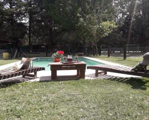 a picnic table and two benches next to a pool at Casa de Campo La Renata in El Pato +10 photos