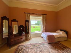 a bedroom with a bed and a window and a dresser at Templemacateer in Westmeath