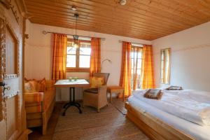 a bedroom with a bed and a desk and a table at Landhaus Am Arzbach in Bad Tölz