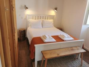 フルナスにあるCasa da Tia Euláliaのベッドルーム1室(白いベッド1台、タオル2枚付)