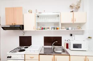 a kitchen with a sink and a microwave at Guest House Kola in Slano