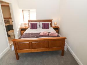 a bedroom with a bed with two pink towels on it at Y Berth Ddu Farmhouse in Caernarfon