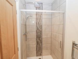 a shower with a glass door in a bathroom at Y Berth Ddu Farmhouse in Caernarfon +19 photos
