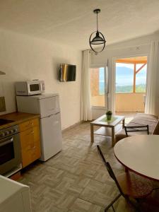 a kitchen and living room with a table and a refrigerator at Apartments Villa Milna 2 in Budva