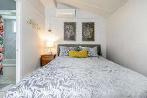 Un dormitorio con una cama y una almohada amarilla. en Motel Rideau, en Brossard