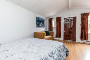 1 dormitorio con cama, silla y ventana en Motel Rideau, en Brossard