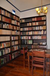 een bibliotheek met een tafel en een bos boeken bij Pouso, Café e Cultura in Pirenópolis