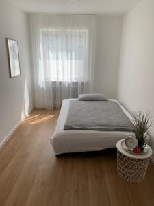 um quarto branco com uma cama e uma janela em Ferienwohnung Alpenstraße em Friedrichshafen