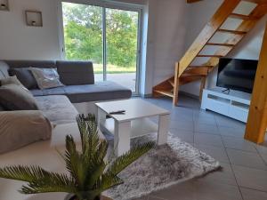 a living room with a couch and a table at La Maison au bord de l'Ain in Charnoz