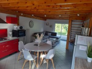 a kitchen and a living room with a table and chairs at La Maison au bord de l'Ain in Charnoz