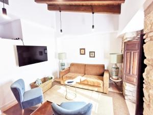 a living room with a couch and chairs at Apartamentos Tres Llaves Palacio de Vela de los Cobos in Úbeda
