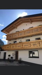 a building with a wooden balcony on top of it at Apart am Inn in Pfunds