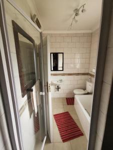 a bathroom with a tub and a toilet and a sink at The Yellow Butterfly in Vereeniging