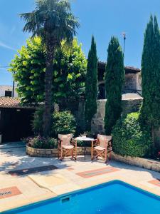 un patio con una mesa, sillas y una palmera en Katsaneiko Mansion, en Afitos