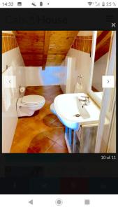 a bathroom with a white toilet and a sink at Porto Antigo 2 in Santa Maria