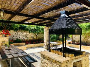 un patio al aire libre con parrilla y mesa en Katsaneiko Mansion, en Afitos