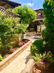 un jardín con flores y plantas y una casa en Katsaneiko Mansion, en Afitos