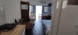 a small room with a bed and a desk and a kitchen at Panorama Oia Apartments in Oia