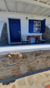 una pared de piedra con una puerta azul y una mesa en Germanos Studios, en Mykonos ciudad
