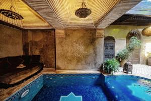 a swimming pool in a room with a couch and a bed at Riad Zhor in Marrakech