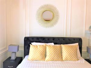 a bedroom with a bed with yellow pillows and a mirror at The Courtfield Plaza in London